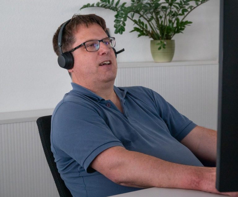 Mitarbeiter vor PC am Telefonieren