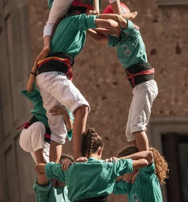 Fünf Frauen bilden das Fundament, damit die Mädchen hinauf Klettern können